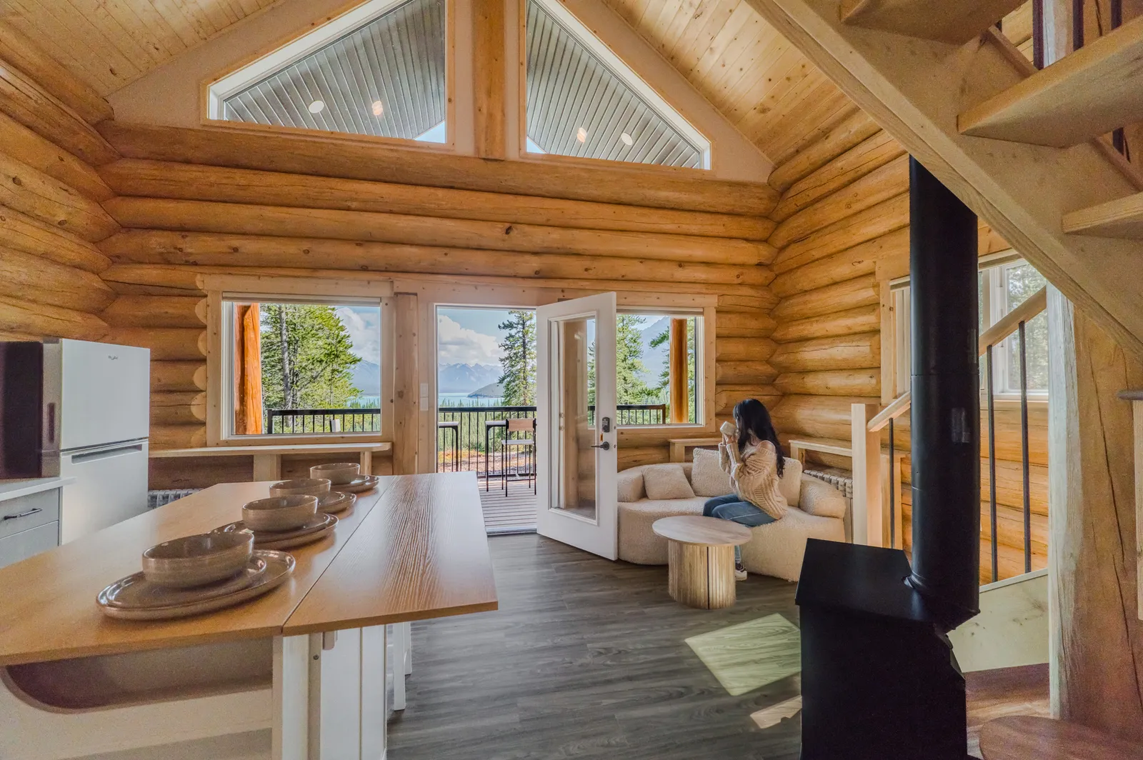 Open-plan log cabin living room and kitchen with lake view